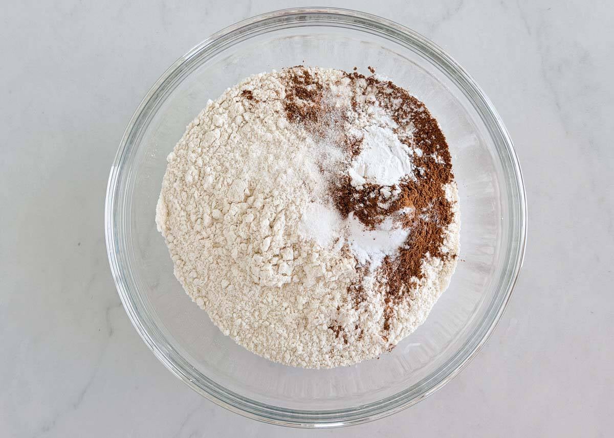 Flour, cinnamon, baking powder, baking soda and salt in a glass mixing bowl.