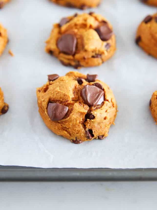 Freshly baked 3 ingredient pumpkin cookies with cake mix on a parchment-lined baking sheet.