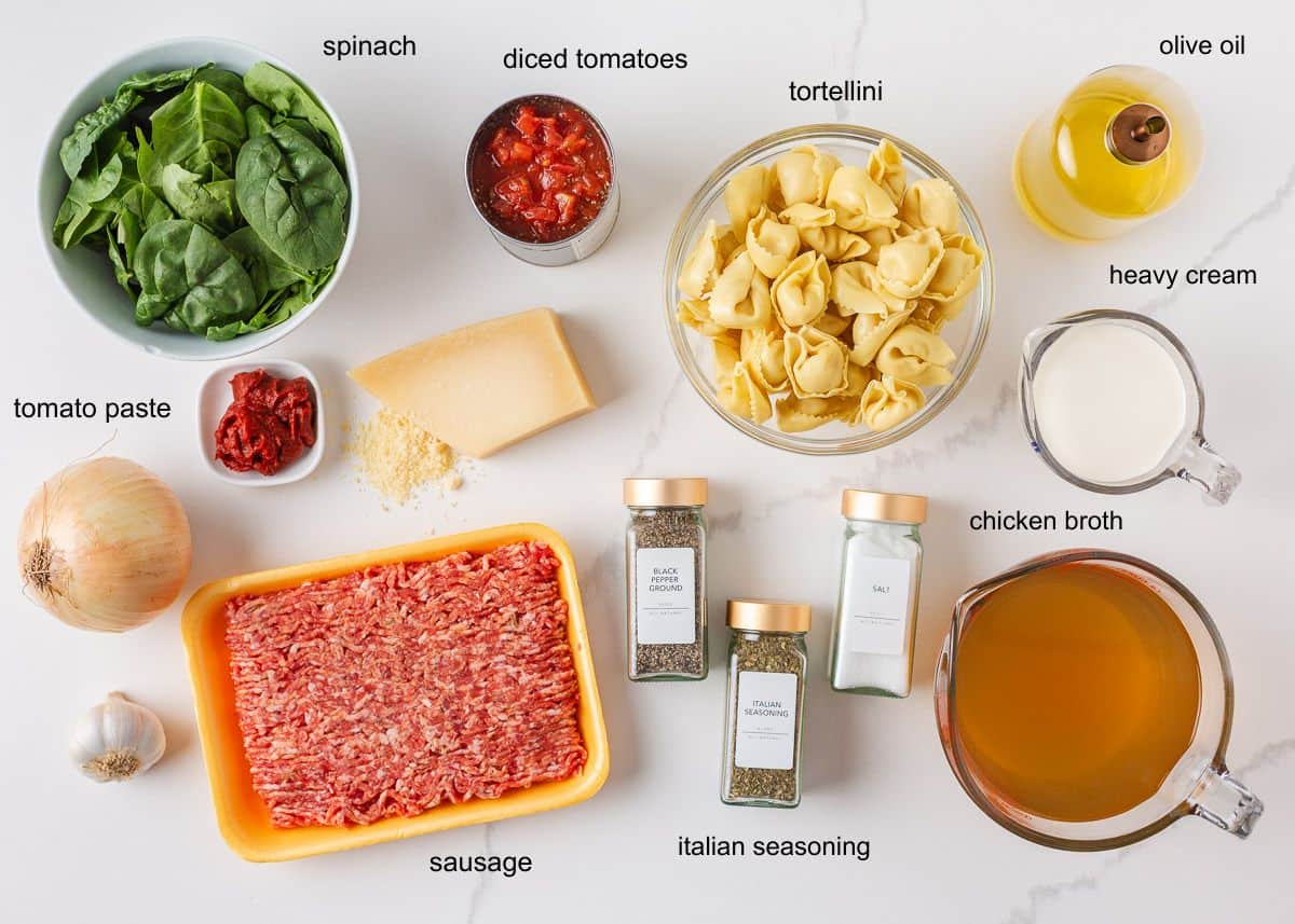 Ingredients for creamy Tuscan tortellini soup including sausage, tortellini, spinach, tomatoes, Parmesan, cream and chicken broth.
