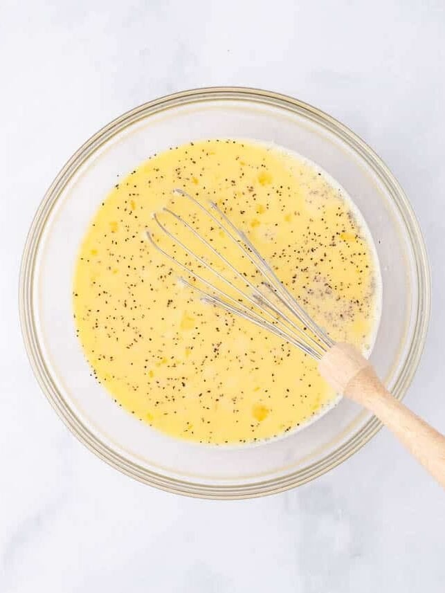 Whisking eggs in a glass bowl.