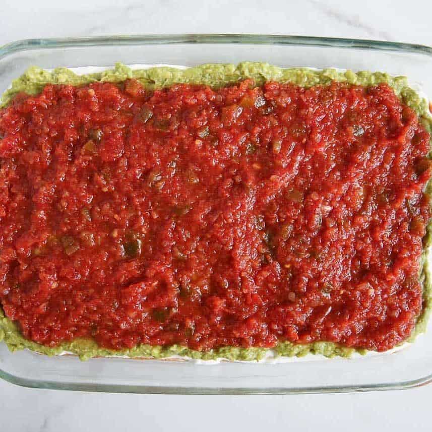 Salsa spread over guacamole layer for 7 layer dip.