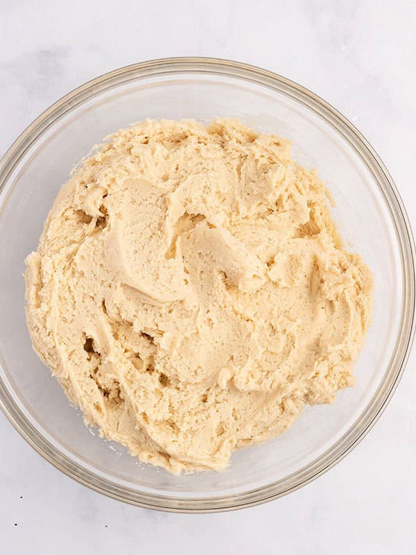 Sugar cookie dough mixed in a glass bowl.