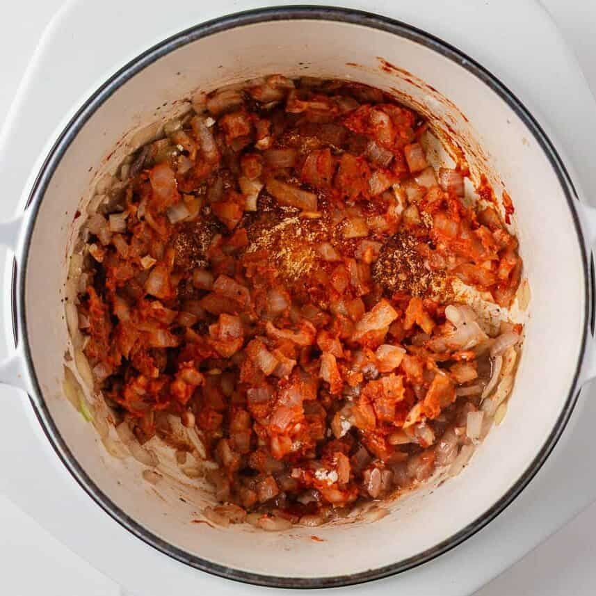 Onion and tomato paste cooking in a Dutch oven for the beef stew base.