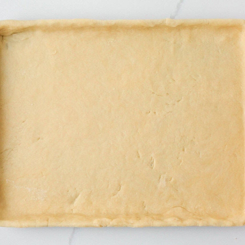 Pie crust pressed into a sheet pan for making mixed berry slab pie.