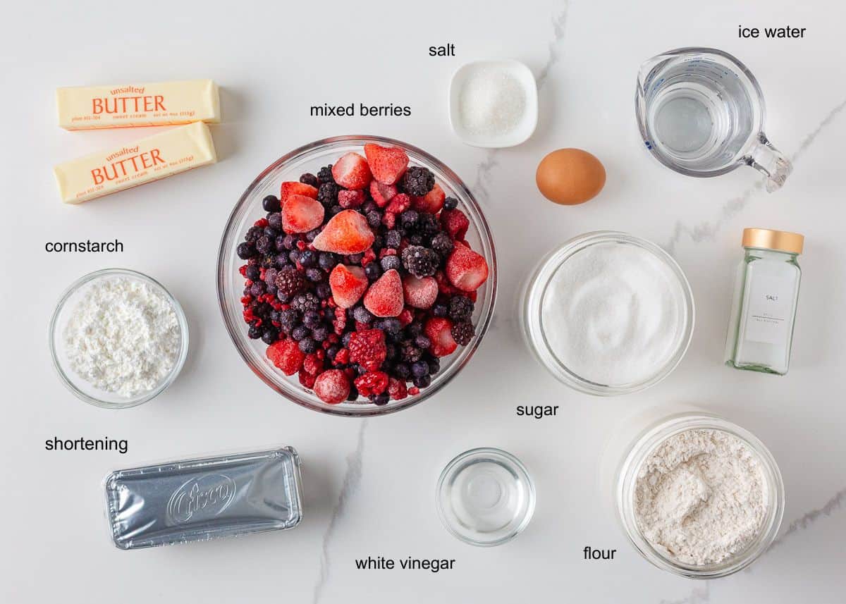 Ingredients for mixed berry sheet pan pie with frozen berries, flour, sugar, butter, egg and water.