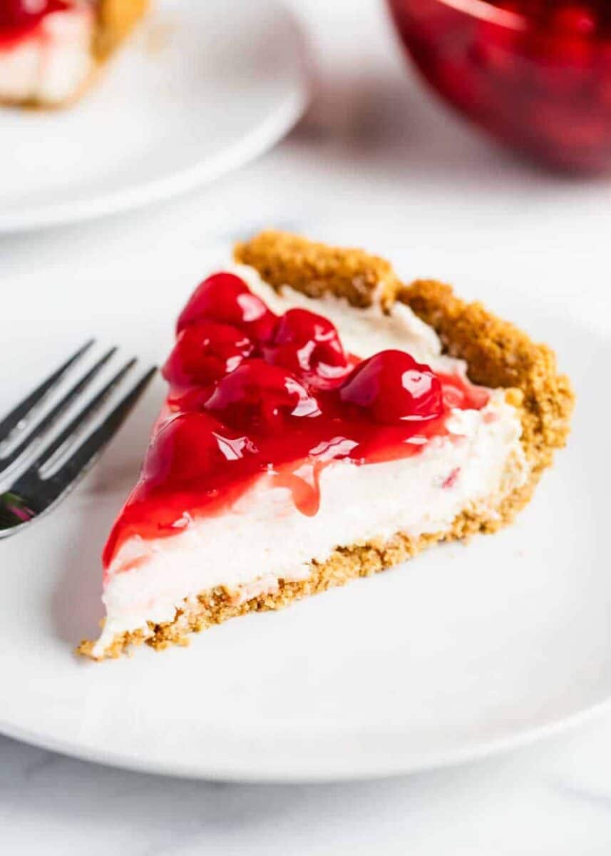 This no-bake cheesecake recipe is perfect for beginners! Only 5 ingredients and absolutely no baking. It's everything a cheesecake should be...silky, smooth, light, creamy and decadent! slice of no bake cheesecake on plate
