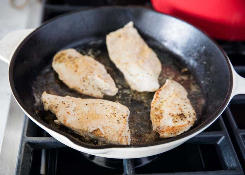 Searing chicken in cast iron skillet.