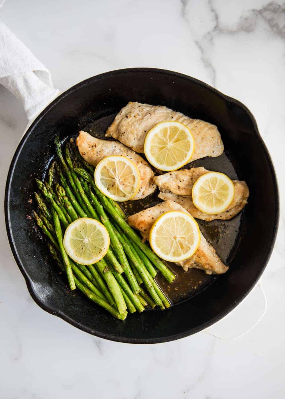 lemon chicken with asparagus in pan 