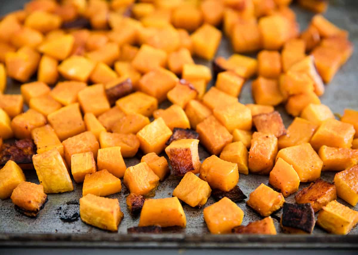 Roasted butternut squash cubes on a baking sheet.