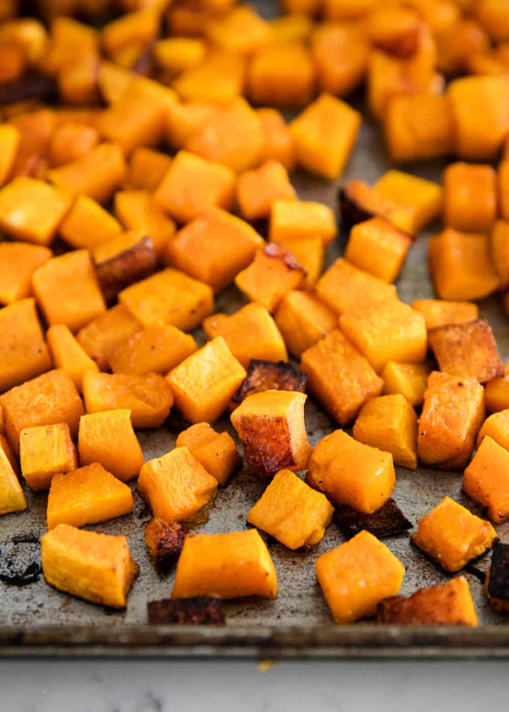 Oven roasted butternut squash on a baking sheet.